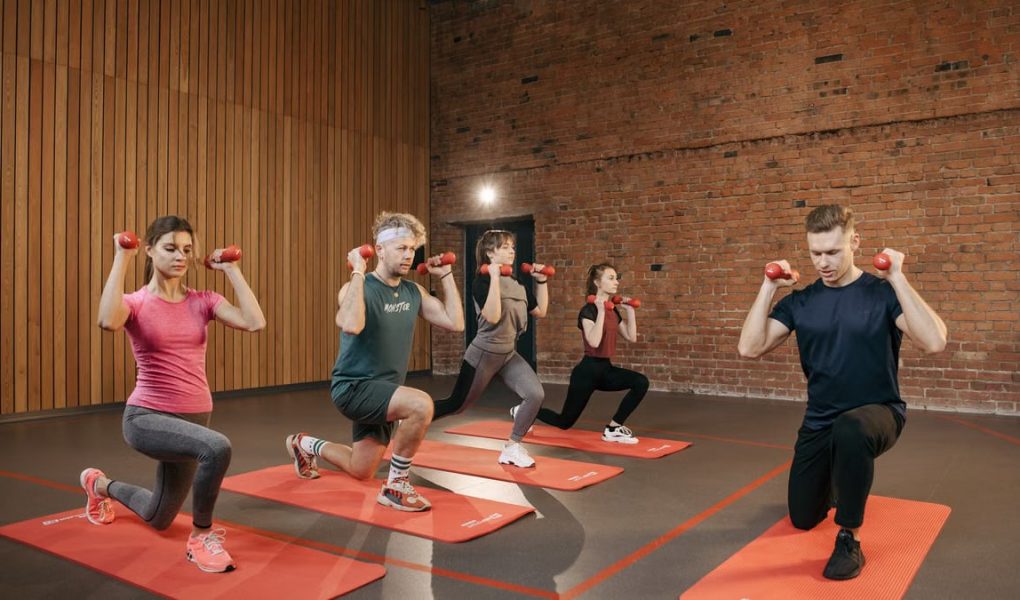 Indoor group workout session with dumbbells focusing on strength and fitness.