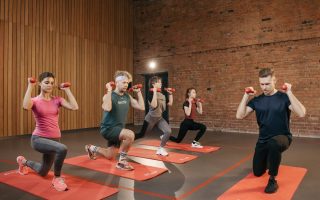 Indoor group workout session with dumbbells focusing on strength and fitness.